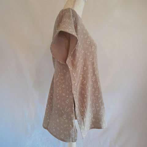 Vista lateral de blusa adaptada beige con apertura lateral discreta para facilitar el vestir.