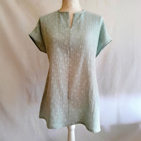 Vista frontal de blusa adaptada para mujer en color verde agua, diseñada para facilitar el vestir con movilidad reducida.