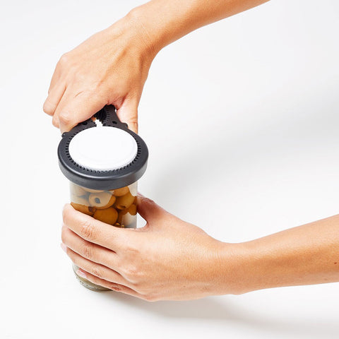 Abridor de tapas universal facilitando la apertura de un tarro con poca fuerza en las manos.