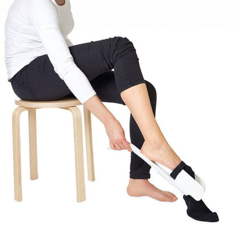 Uso del calzador de calcetines sentado, ideal para personas con dificultad para agacharse.